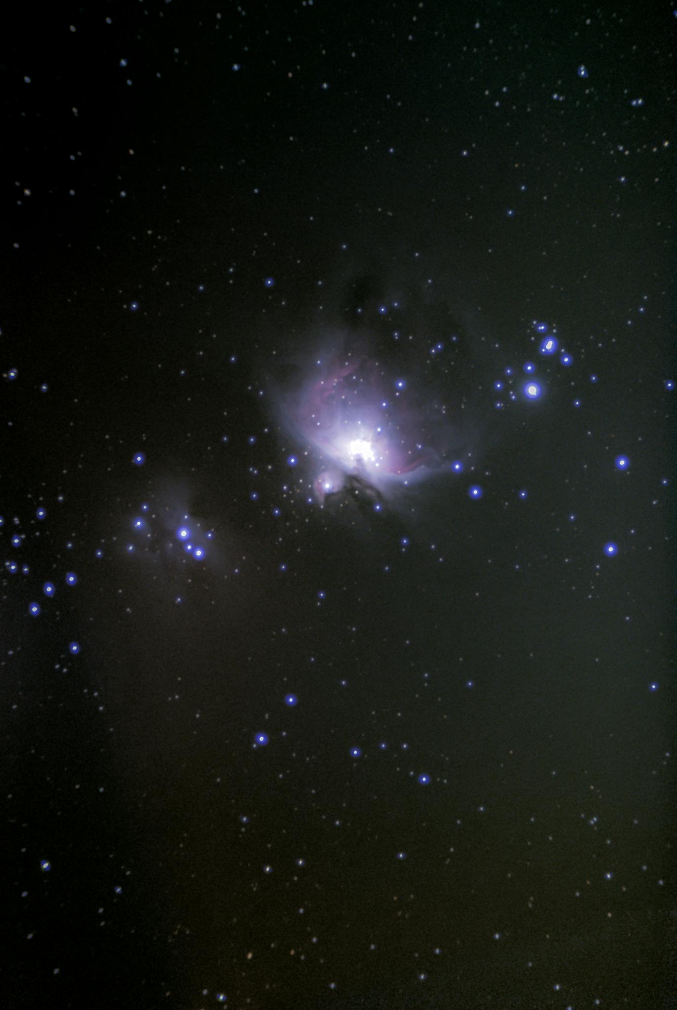 A mesmerizing view of the Orion Nebula surrounded by a starry night sky, showcasing the wonders of outer space.